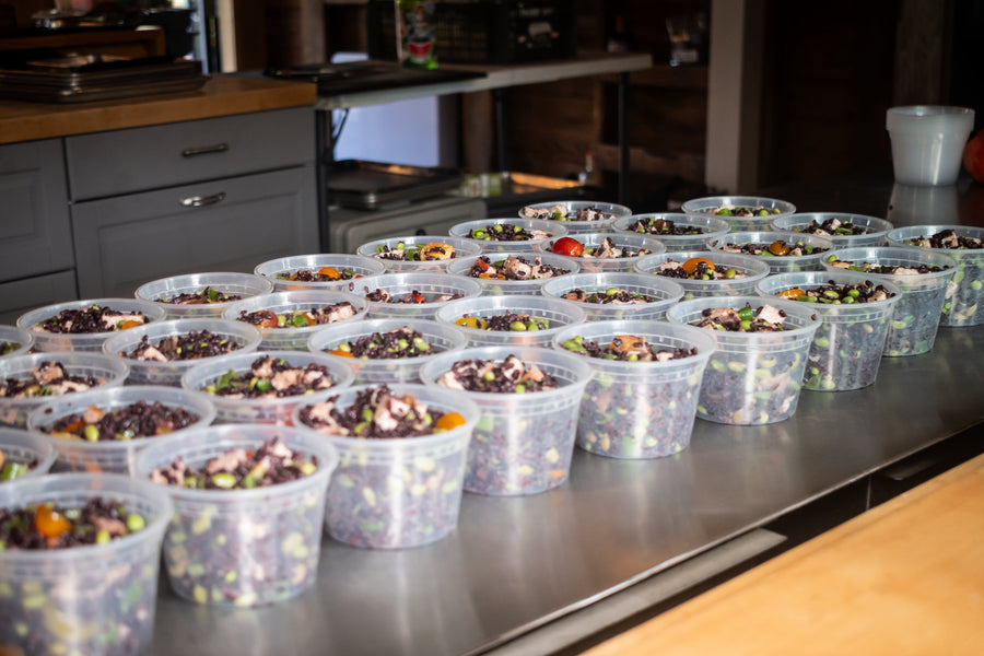 Dozens of Maven Meals dishes portioned into containers on the SeaTac kitchen bench