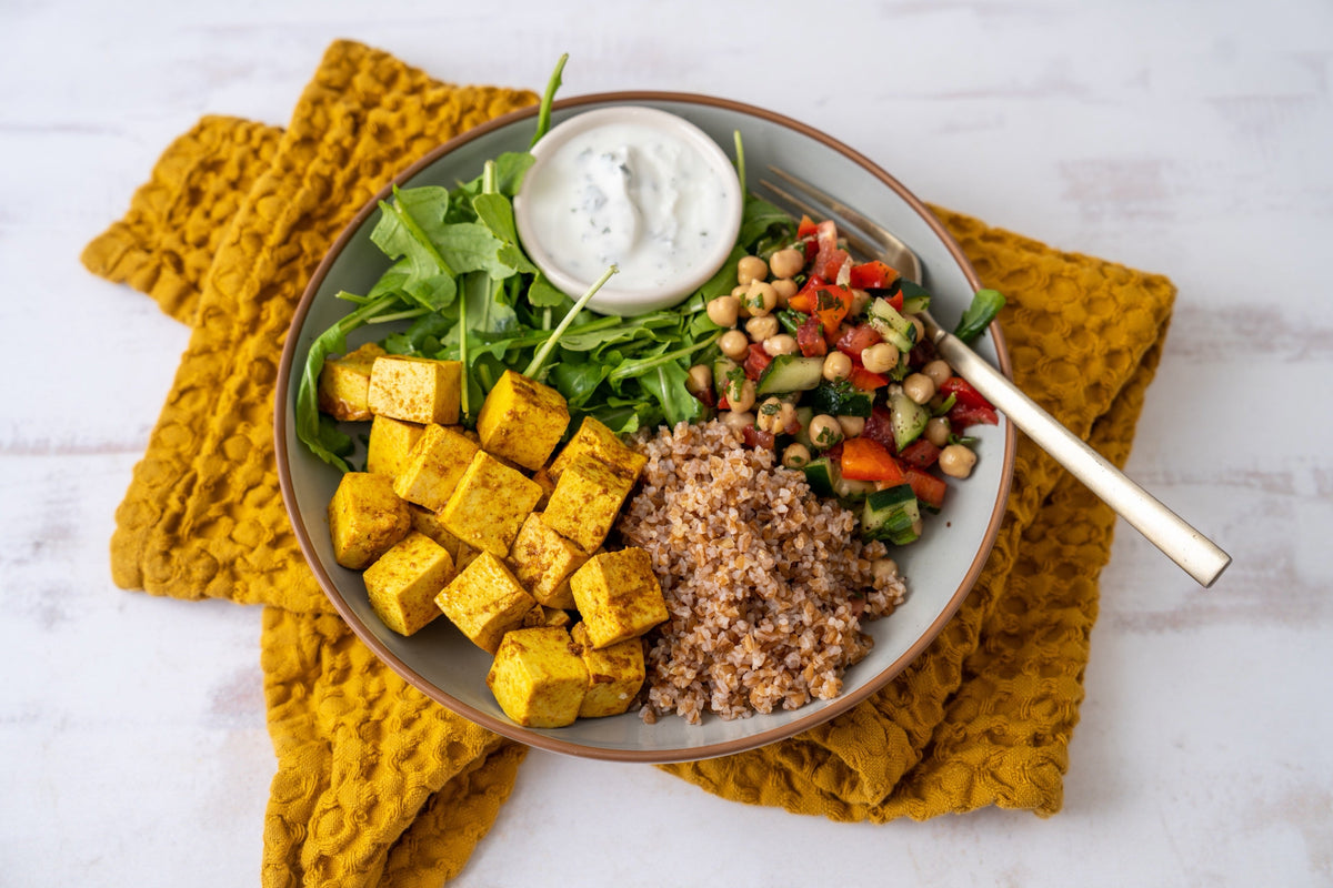 A Maven Meals tofu shawarma bowl with bulgur, chickpea and cucumber salad, arugula and herbed yogurt