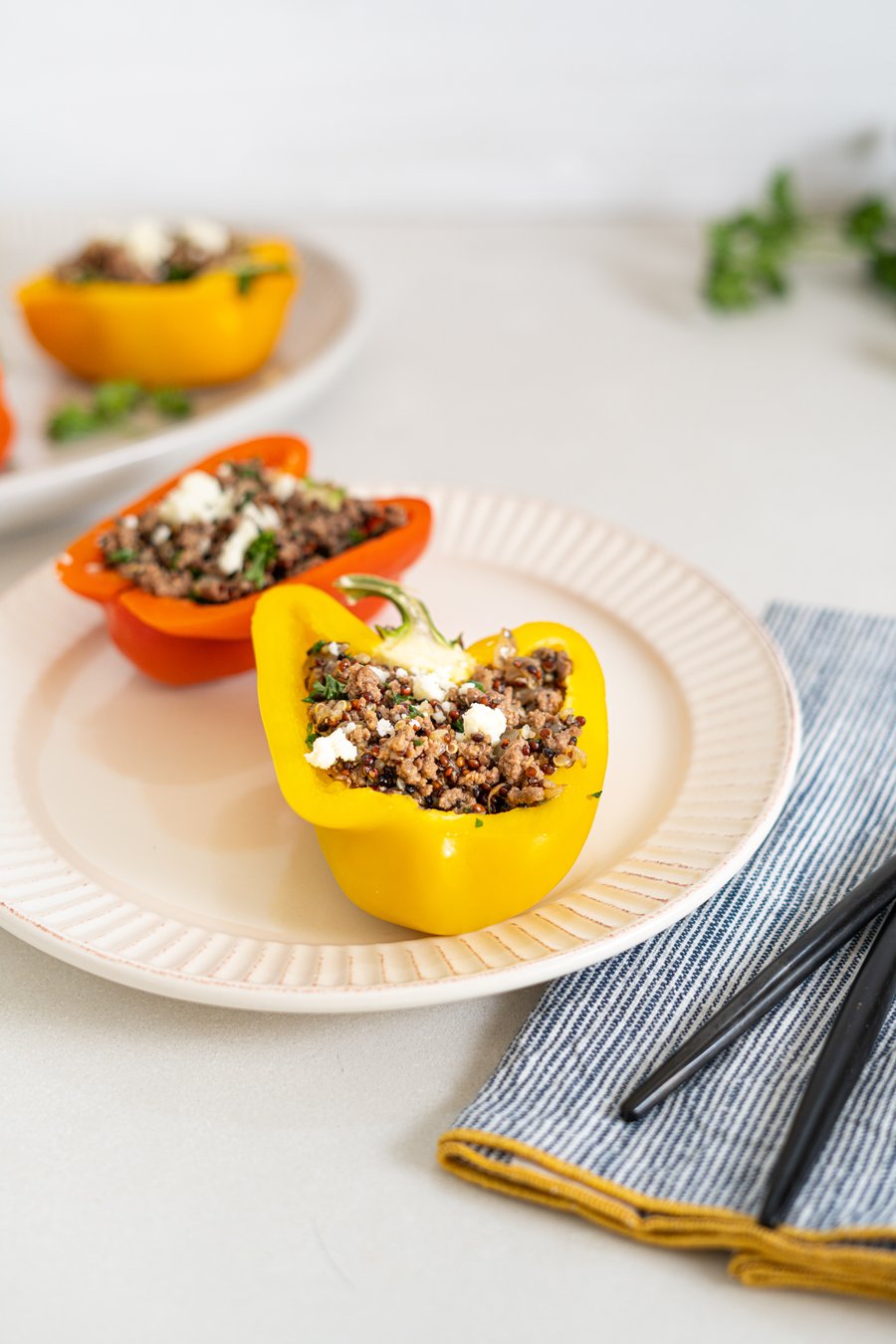Bell peppers stuffed with quinoa, lamb and herbs, topped with feta